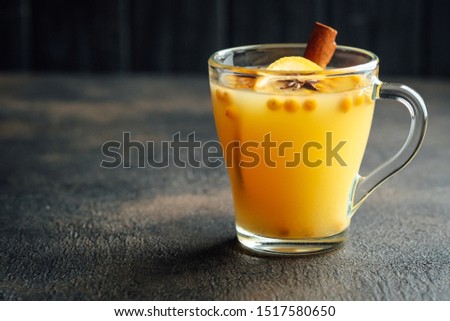 sea buckthorn tea with orange and spices on a dark background