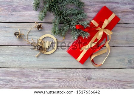 Decoration of a New Year or Christmas table. Christmas tree branches, suspension and gift on a wooden table close-up