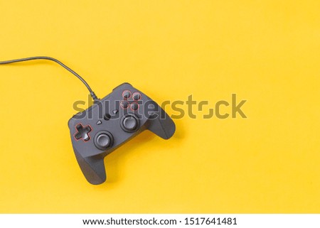 Black joysticks on yellow background. Computer game competition. Gaming concept. Place for text. Flat lay, top view, copy space.