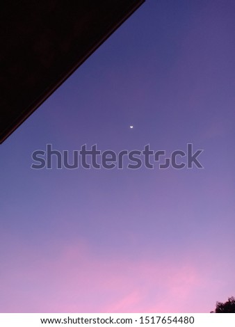 outstanding picture of visible moon taken at dawn with purple sky
