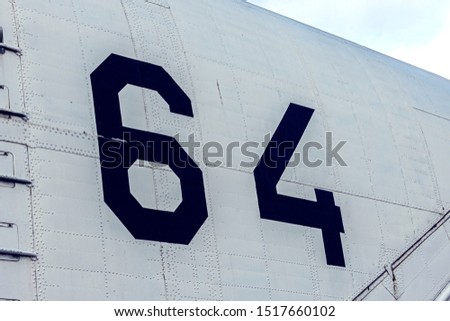 64 digit in black on a white wall, background, texture