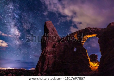 Two light sources on Turret Arch: one manmade, one mother nature, Lightning, light up Turret Arch in Arches National Park, Utah. Royalty-Free Stock Photo #1517697857
