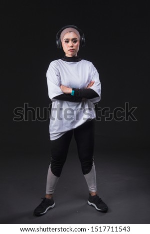 A beautiful hijab girl wearing white shirt ,headphone and smart band watch with various pose, dark background, studio light.