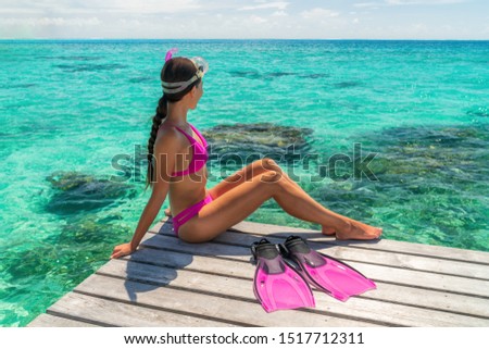 Beach vacation sport girl ready to snorkel in coral reefs of perfect turquoise waters in Tahiti, French Polynesia. Active watersport travel lifestyle adventure snorkeling trip.