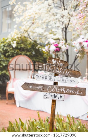 Signpost showing directions for alice in wonderland themed wedding