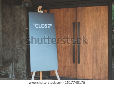 Close sign board front of the wooden door of restaurant or coffee shop.