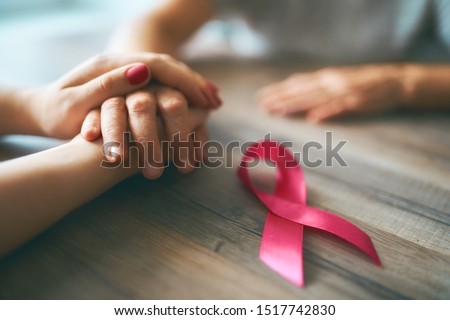 Females hands. Top view, close up. Pink ribbon like a symbol of Breast Cancer Awareness. Royalty-Free Stock Photo #1517742830