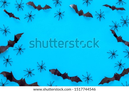 Stylish Halloween design. Bats and spiders on blue background top view copy space frame
