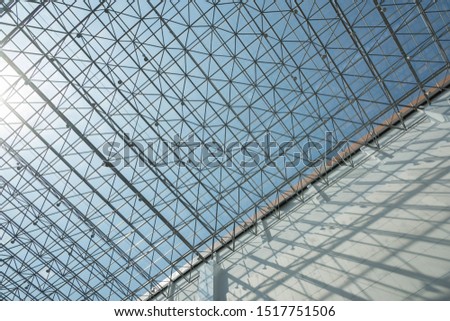 Sunlight shining on modern indoor metal grid roof with concrete wall light and shadow space
