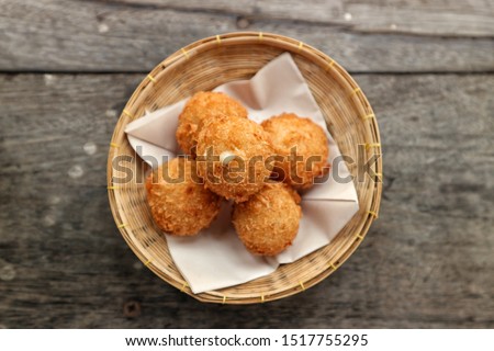 Cheese ball crispy in a basket woven with oil blotting paper.Wood background.Is a food menu for young children.Soft focus food picture.