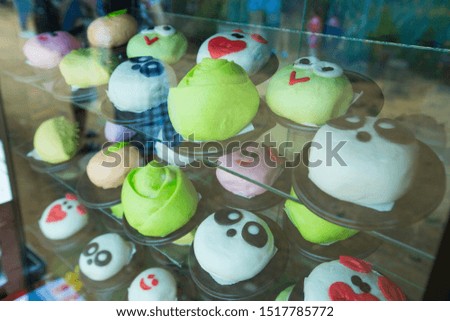 Steamed buns made in a variety of cartoons, in a variety of colors in the steamer, showing the appearance that is fresh and hot.
