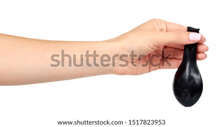 Hand with black inflateble balloon, party event decoration, glossy ball. Isolated on white background.