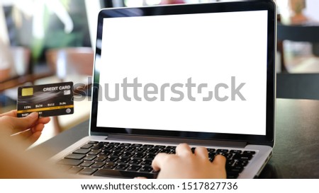 Close up of man using blank laptop and credit card sending massages shopping online or reporting lost card, fraudulent transaction within the coffee shop