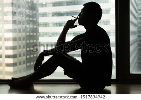 Man smoking a cigarette in the city. Addiction to nicotine. Royalty-Free Stock Photo #1517834942