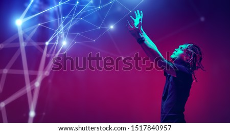 Cyborg raised his hands and looks at the light pouring from above. Biological human robot with wires implanted in the head. Technologies of the future. Copy space. Royalty-Free Stock Photo #1517840957