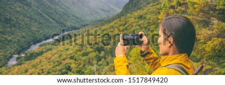Travel hike woman hiker taking photo with phone of landscape of trail hiking in Quebec autumn foliage background panoramic banner. Canada fall camping lifestyle.