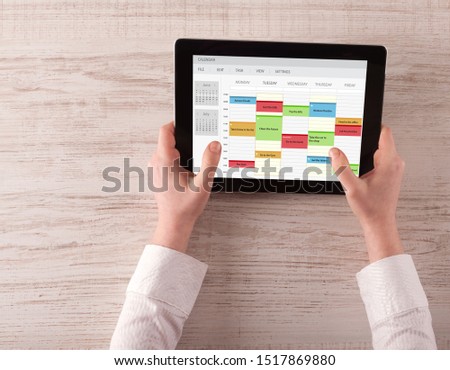 Hand holding tablet with timetable and calendar concept