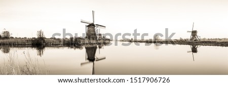 Sephia panoramic landscape image of a windmills in The Netherlands.