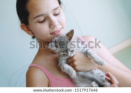 Girl hugs Cute sweet Kitten gray, fluffy, playful.