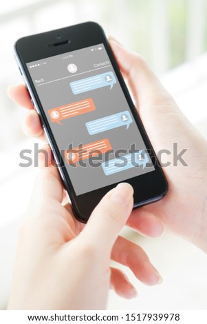 Woman hand holding phone with app messenger on the screen