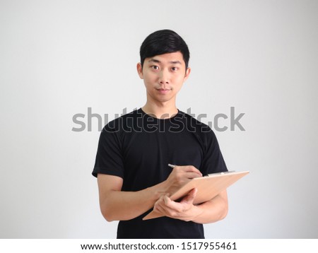 Asian man black shirt happy smile look at camera holding clipboard and silver pen in hand on white isolated,Worker concept