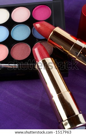 Detail of assortment of makeups.  Macro shot on malva background. Very shallow dof