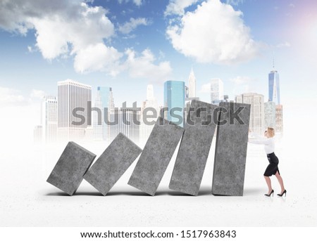 Young businesswoman holding declining concrete graph over cityscape background. Concept of financial crisis and real estate market.