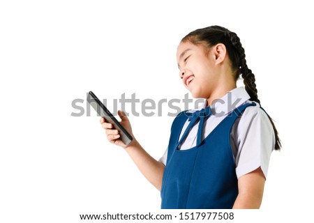 portrait of smiling, little girl in school uniform  touch the screen a digital device(pad, mobile, note) isolated white