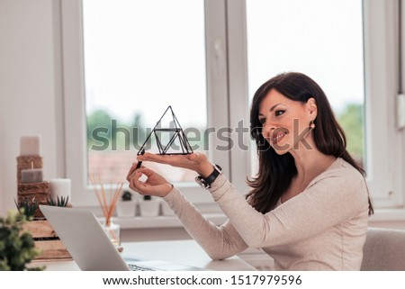 Beautiful woman working with 3D pen at cozy home office.