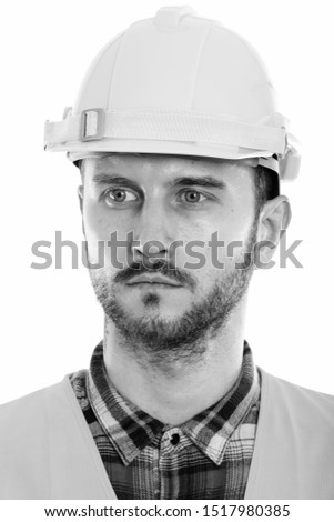 Face of young man construction worker thinking while looking at distance