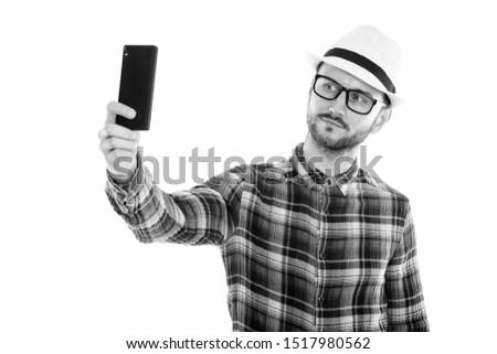 Studio shot of young man taking selfie picture with mobile phone