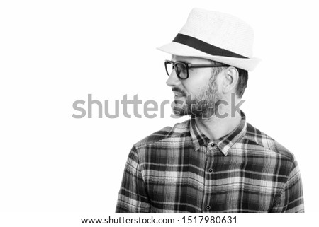 Profile view of happy young man smiling while wearing hat and eyeglasses