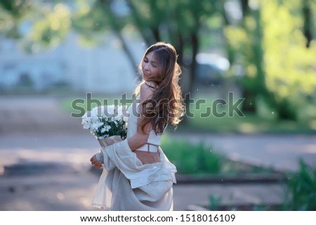 happy girl with flowers in the city / summer photo young beautiful girl holding a bouquet of flowers on a city street