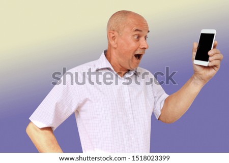 funny man in a light shirt with a silly look looks, opening his mouth to his smartphone, technology concept, horizontal, close-up, copy space
