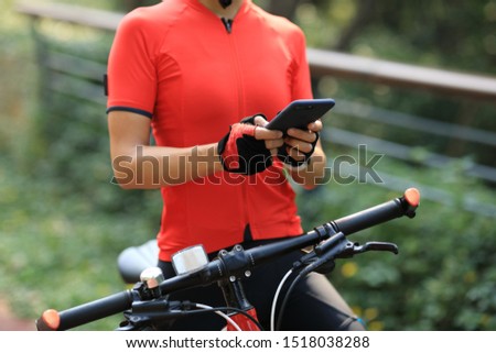 Riding on bike path,using smartphone while riding bike on sunny day