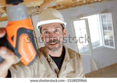 portrait of a worker drilling ceiling