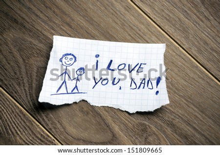 I love you, Dad written on piece of paper, on a wood background