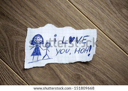 I love you, mom written on piece of paper, on a wood background