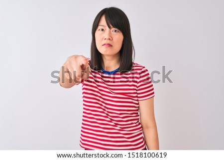 Young beautiful chinese woman wearing red striped t-shirt over isolated white background pointing displeased and frustrated to the camera, angry and furious with you