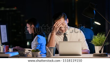 asian businessman overtime work and has headache in the office Royalty-Free Stock Photo #1518119150
