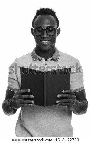 Young happy African man smiling while reading book