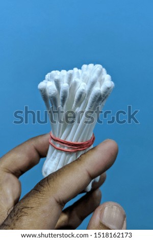 Hand holding of cotton swab or bud.