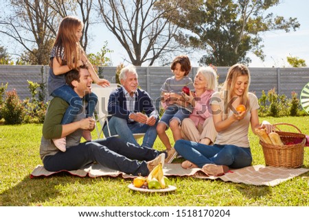 Happy family with children and grandparents celebrates birthday in the garden