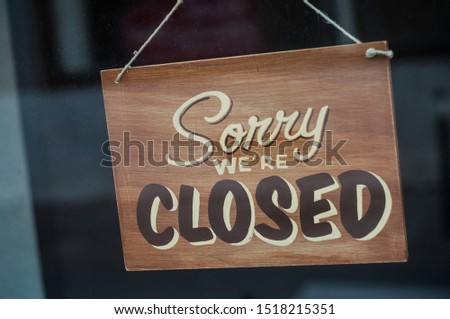 Closeup of wooden panel on store front : Sorry we are closed