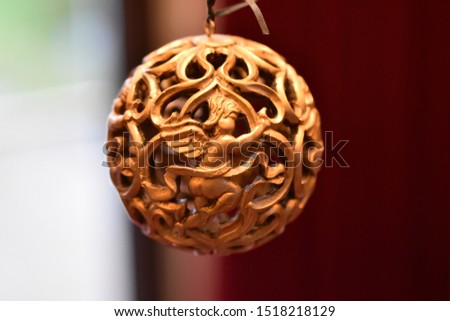 Decorative ornament hanging in front of blurry background.