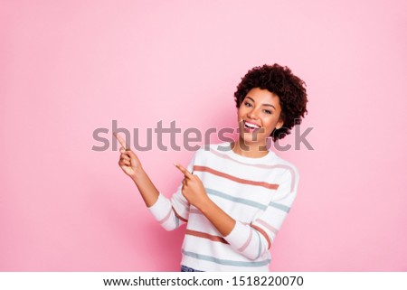 Photo of amazing dark skin wavy lady indicating fingers up empty space showing low prices shopping wear striped pullover isolated pastel pink color background