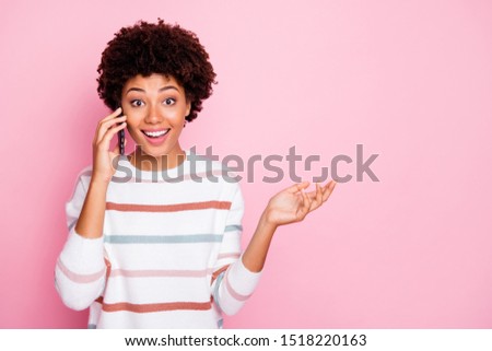 Photo of pretty excited dark skin lady holding telephone talking with best friend wear white striped pullover isolated pastel pink color background