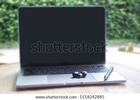 Modern laptop computer on wooden table in home garden, stock photo