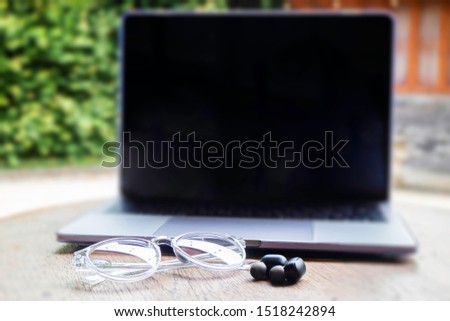 Modern laptop computer on wooden table in home garden, stock photo