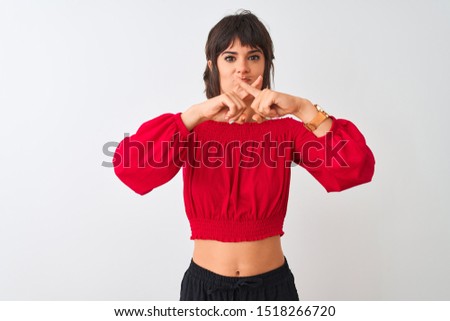 Young beautiful woman wearing red summer t-shirt standing over isolated white background Rejection expression crossing fingers doing negative sign